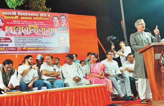 Member of Parliament Anil Desai speaking while Aditya Thackeray and others are sitting on the stage. Photo: INN