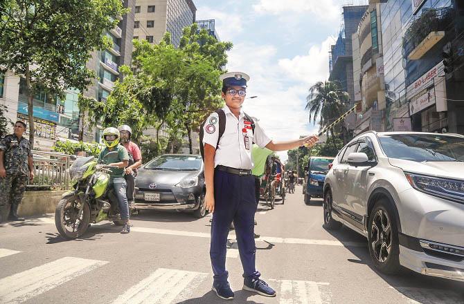 A student performing his duty as a traffic officer at an intersection in Dhaka. Photo: PTI