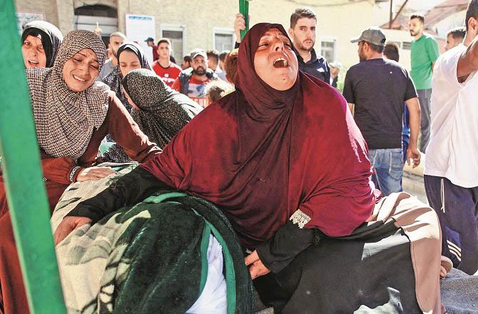 Women mourn the death of their loved ones outside a Gaza hospital. Photo: INN