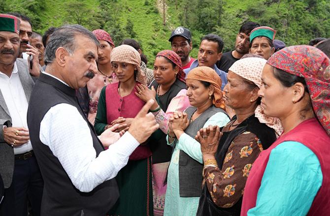 Himachal Pradesh Minister Sukhvinder Singh Sukhu talking to the victims of the village. Photo: PTI