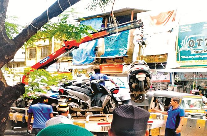 Vehicles parked illegally on the side of the road in Maloney are being towed away. Photo: Inquilab