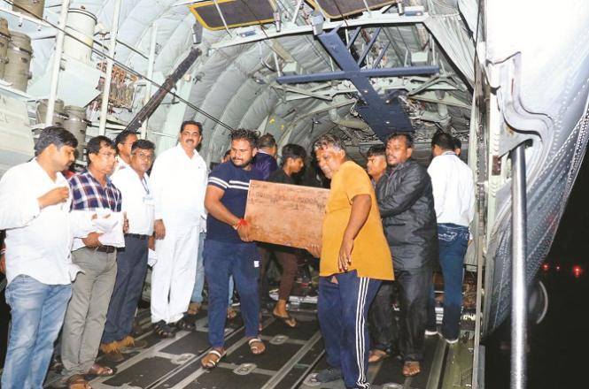 Dead bodies in coffins are being unloaded from the cargo plane at Jalgaon airport. Photo: INN