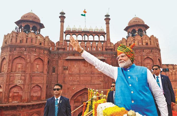 Prime Minister Modi waving his hands from the ramparts of the Red Fort and welcoming the citizens and guests present there. Photo: PTI