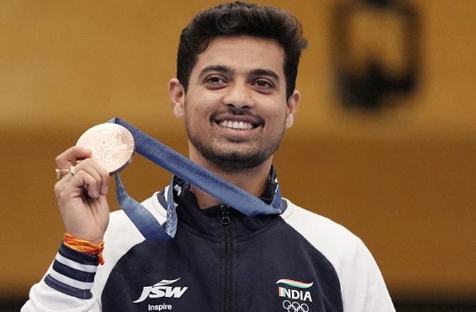 Swapnil Kusale showing the medal. Photo: PTI.