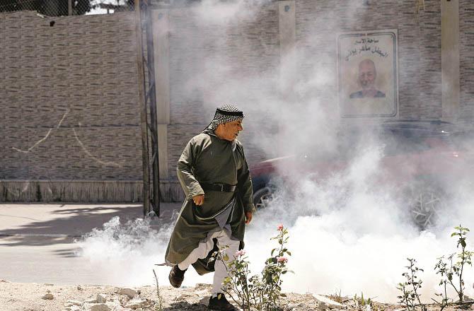 A Palestinian man runs after being attacked by Israeli forces in the West Bank. Photo: INN