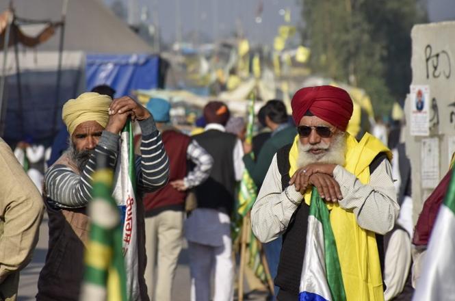 Farmers can be seen standing near the barricades set up by the police. Photo: PTI