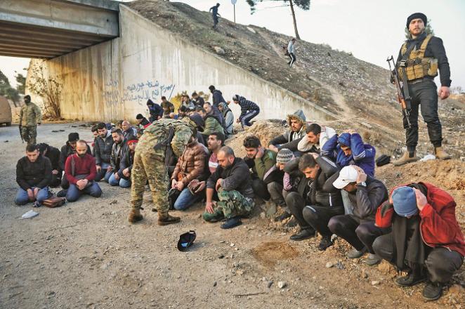 Syrian and coalition soldiers who have been captured by rebels sit on the roadside between Homs and Damascus. Photo: AP/PTI