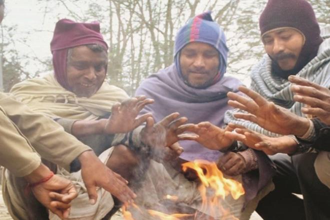 People are sitting around the bonfire to avoid the cold. Photo: INN