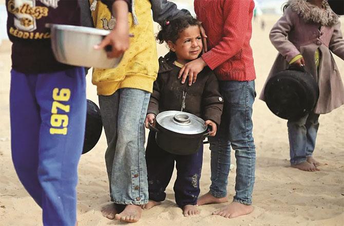 Children line up to get food in Gaza.