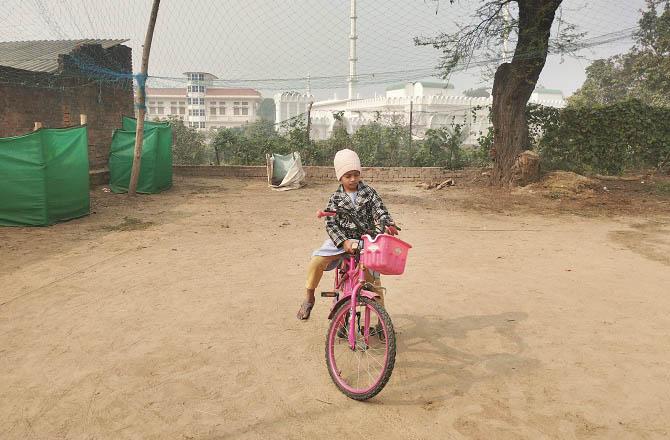 A girl is riding a bicycle on the volleyball field after sunrise. Photo: INN