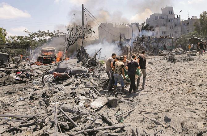 Rescue workers carry a body after the Israeli attack on Gaza. Photo: PTI.