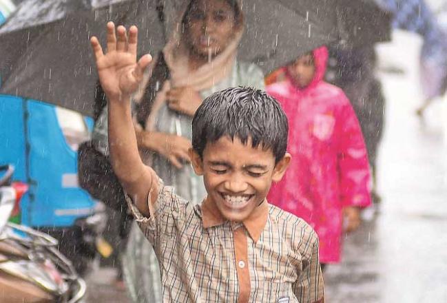 A student enjoys the rain in Mumbai. Photo: INN