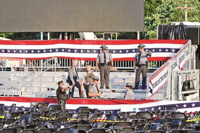 Police officers inspect a meeting hall after a shooting in downtown Butler. Photo: INN