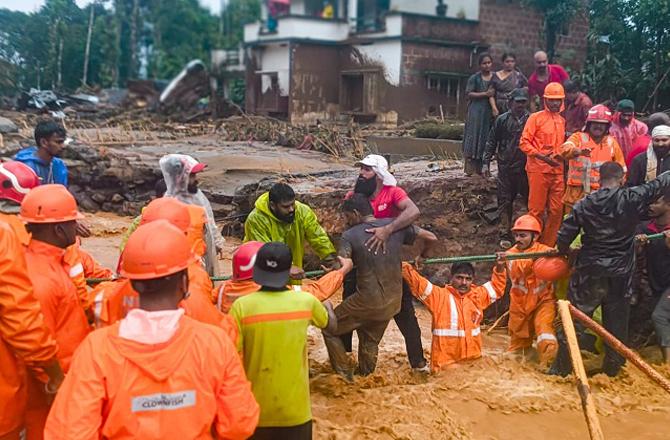 Officials can be seen doing relief work after the landslide. Photo: PTI