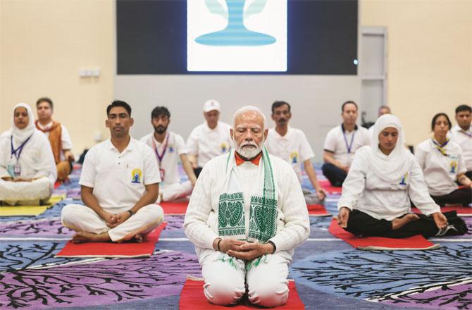 Prime Minister Modi doing yoga with other participants in the conference hall. Photo: INN