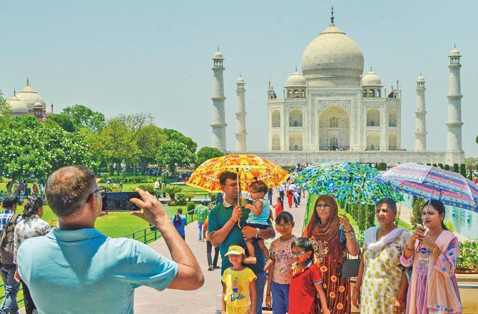 Youngsters are also forced to use umbrellas to avoid the intense sun in Delhi. Photo: INN