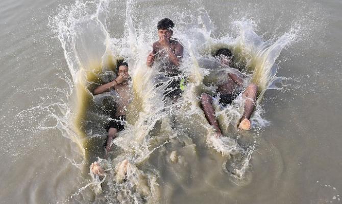 Guwahati: Boys are bathing in the pond to escape the heat. Photo: PTI