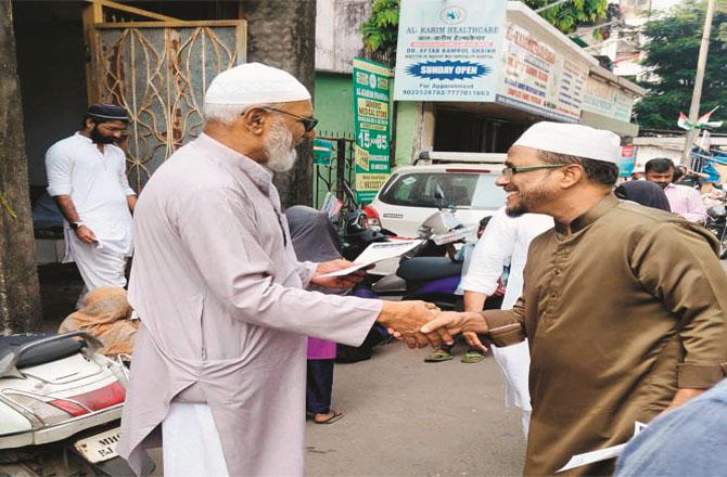 An elderly Jamaat-e-Islami volunteer distributing handballs outside the mosque