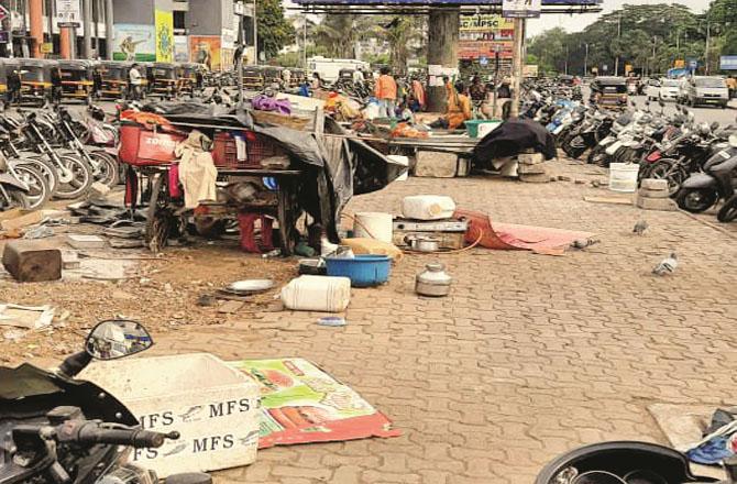 The belongings of beggars and homeless people are seen lying on the footpath outside the Nerul railway station.