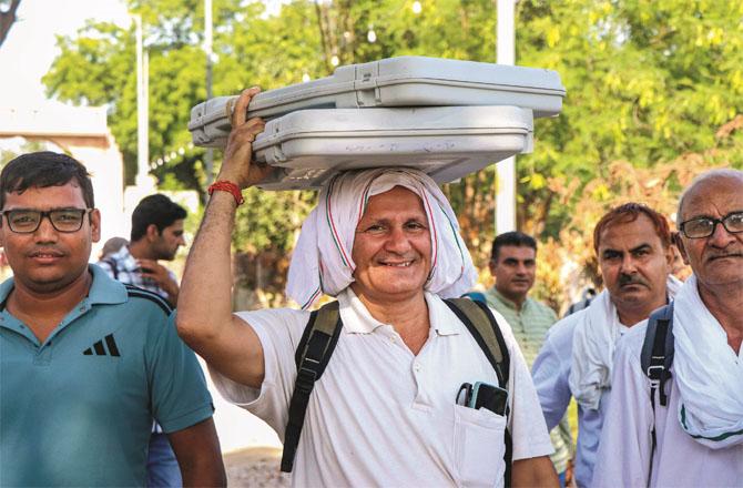 Polling officer carrying EVM for Haryana election.