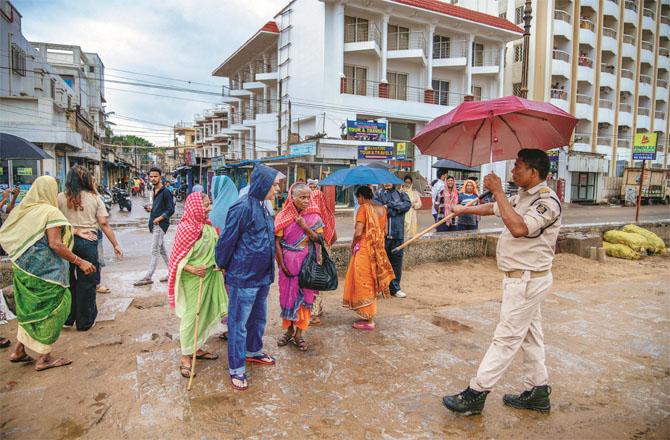 Policemen evacuate people on the beach in Puri, Odisha ahead of the storm. Photo: INN