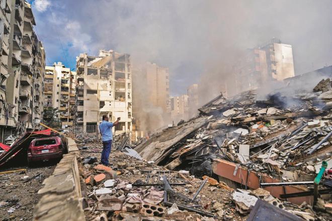 A man takes a picture of a building turned into a pile of rubble after the Israeli attack on southern Lebanon. Photo: INN