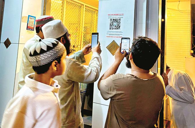 Muslims scanning the QR code at Tayyaba Masjid in Maloney Mahada. Photo: INN