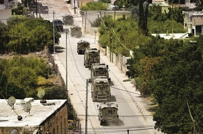 Israeli armored vehicles drive past the Jenin refugee camp. Photo: AP/PTI