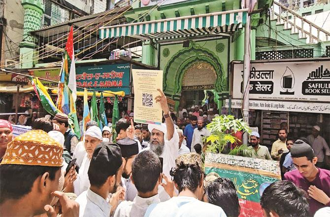 Outside the Sunni large mosque in Madanpura, officials appeal to scan the QR code.