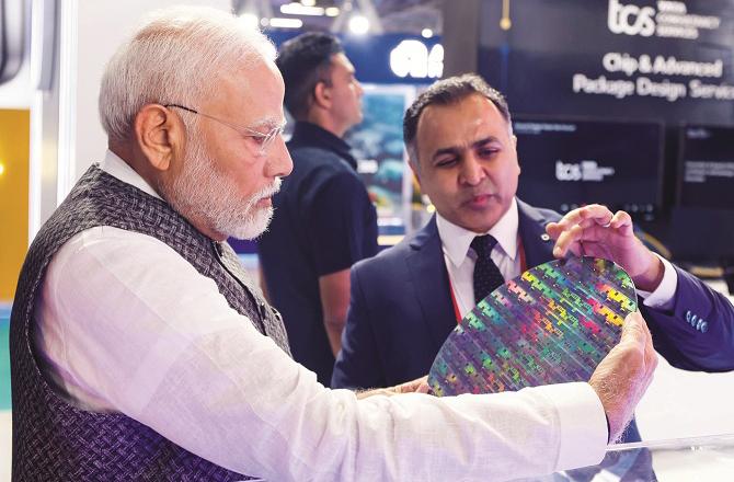 Narendra Modi inspecting the chip at Semicon India 2024. Photo: PTI.