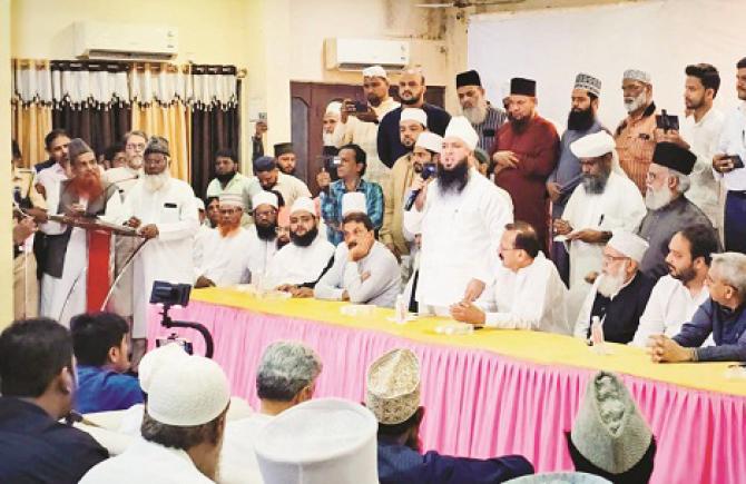 Moin Mian addressing the meeting held at Khilafat House on Saturday while important political and social figures are also present. Photo: INN