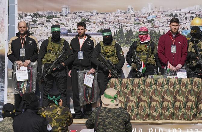 Hamas member with Israeli hostages. Photo: PTI