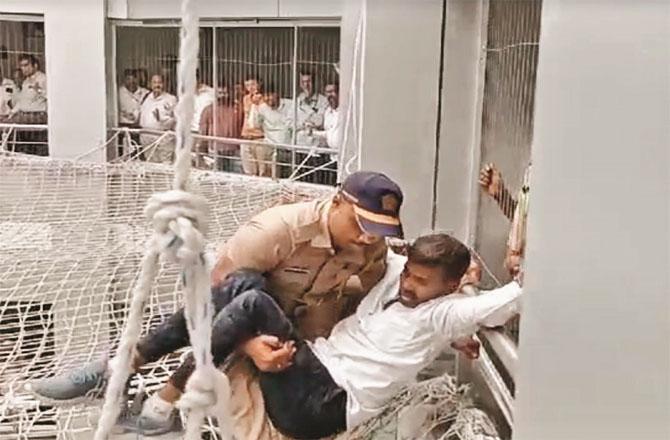 The farmer who fell on the safety net being picked up by the policemen. Photo: INN