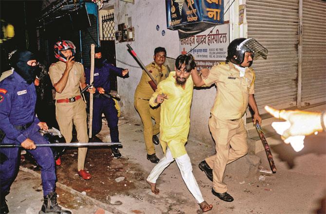 Police officers arrest and take away a suspect during a combing operation. Photo: PTI